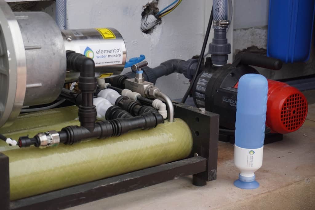 Bottle standing next to the reverse osmosis filter and the intake pump, filled with desalinated water