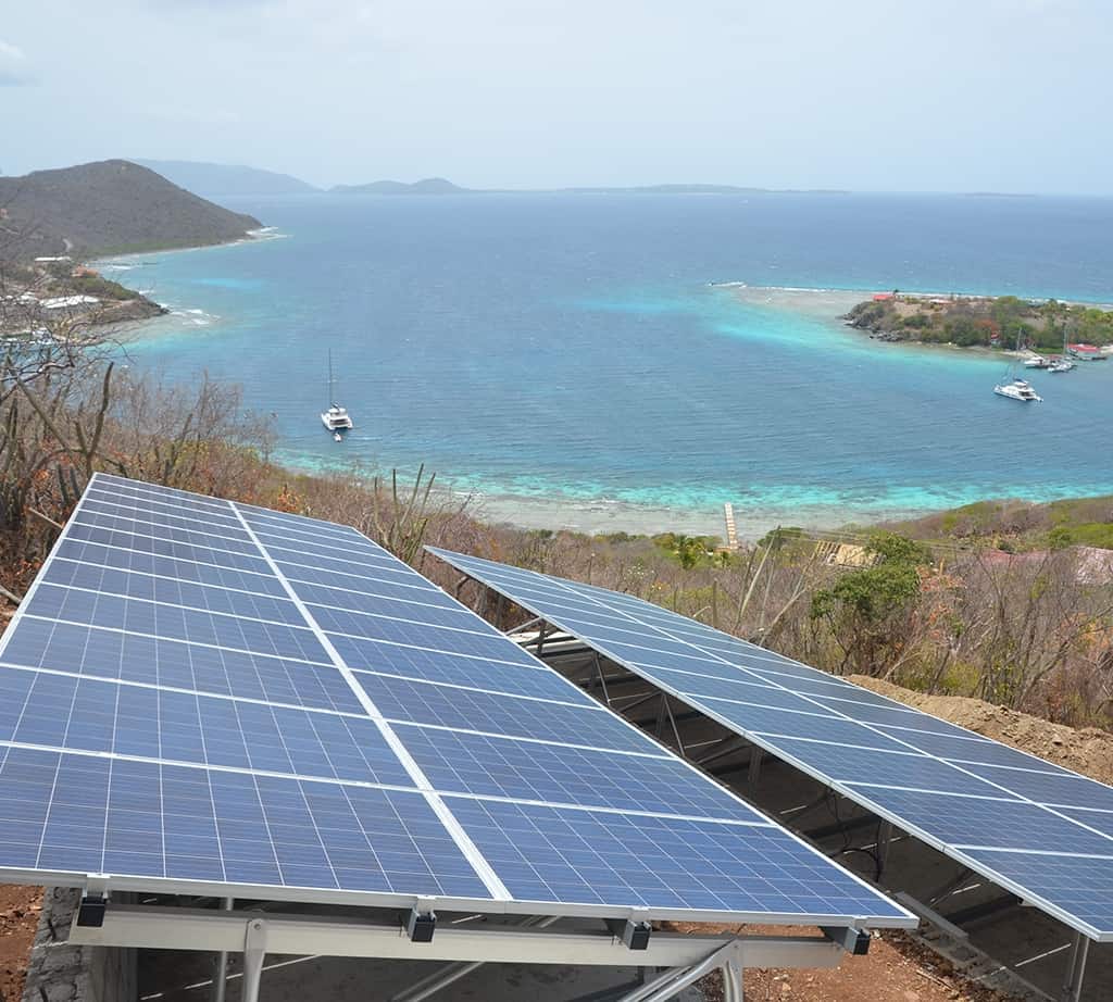 Solar panels placed on a hill close to the shore, providing the energy for the reverse osmosis desalination process using gravity