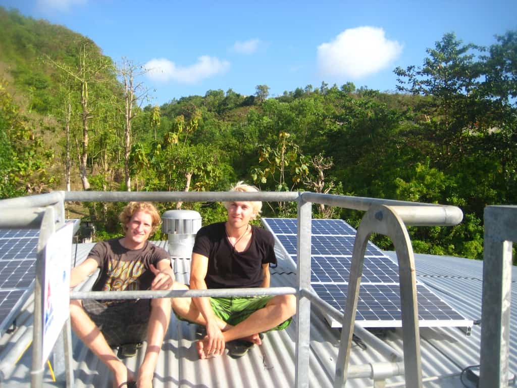 The founders of elemental water makers when they were still young, sitting next to solar panels in Indonesia