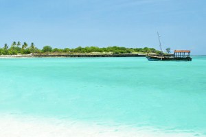 Beautiful beach in Mozambique with a fishing boat crossing