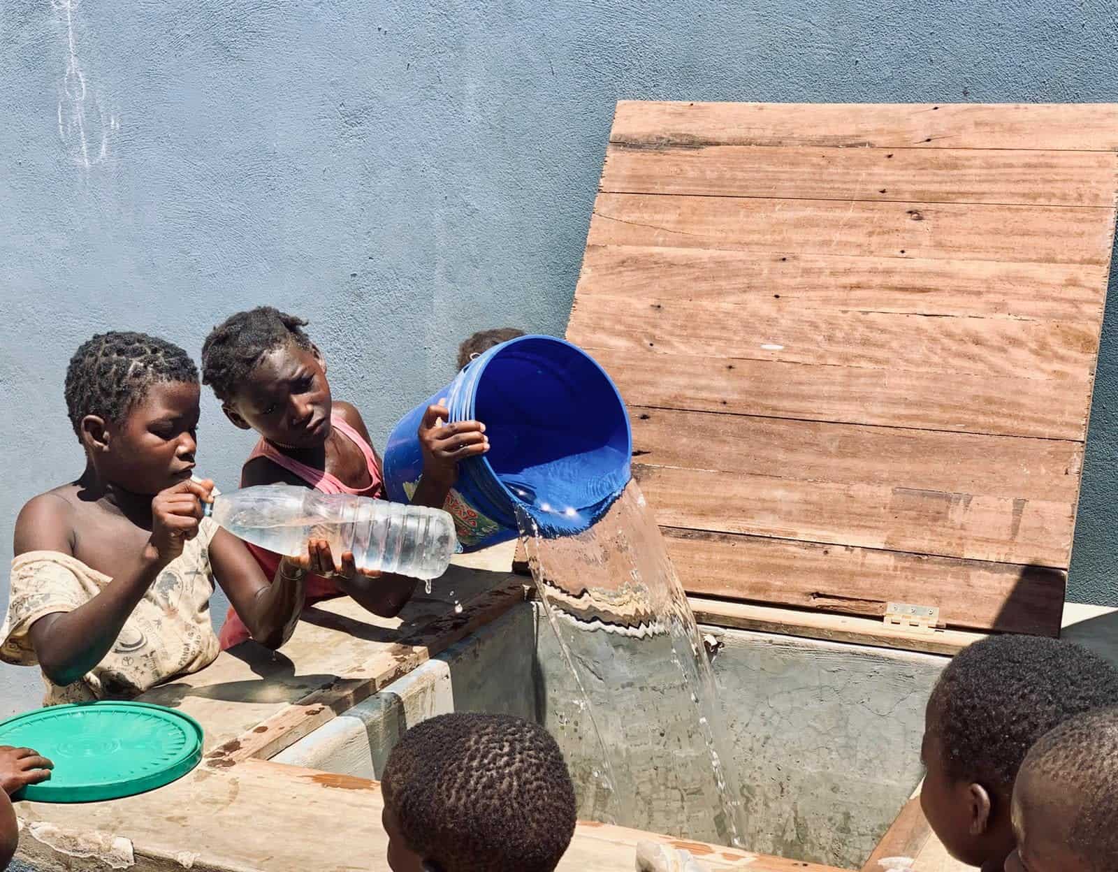 Mozambique children filling up their drinking water supplies which they collected at the desalination unit of elemental water makers