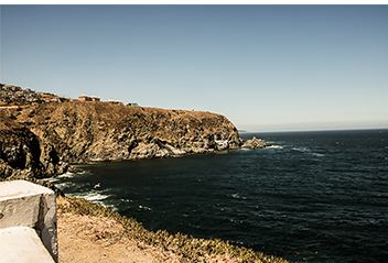 Rocky desert-like coastline in Chile with the waves rolling into the bay and shaping the coast.